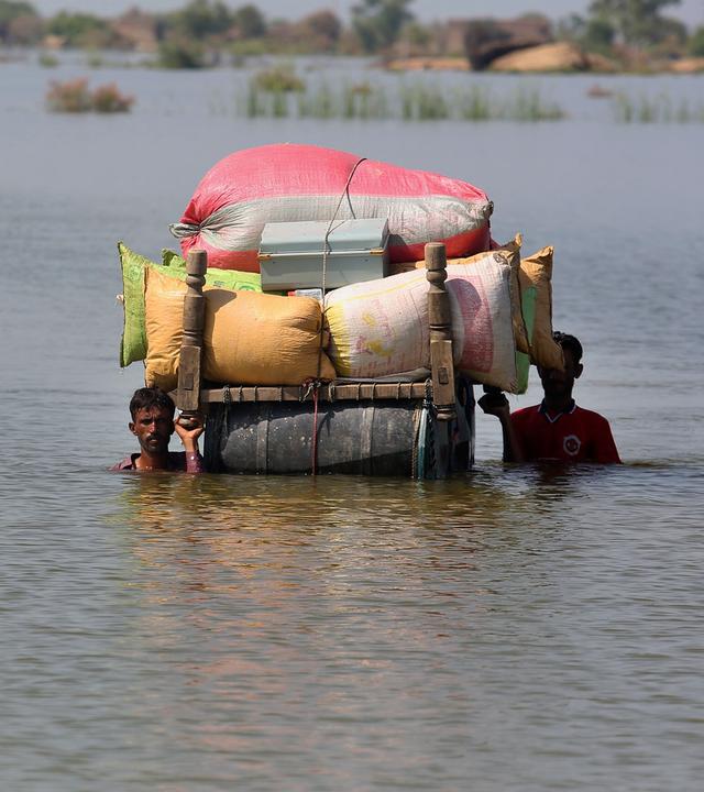 Mensch flüchten mit Hab und Gut vor dem Hochwasser