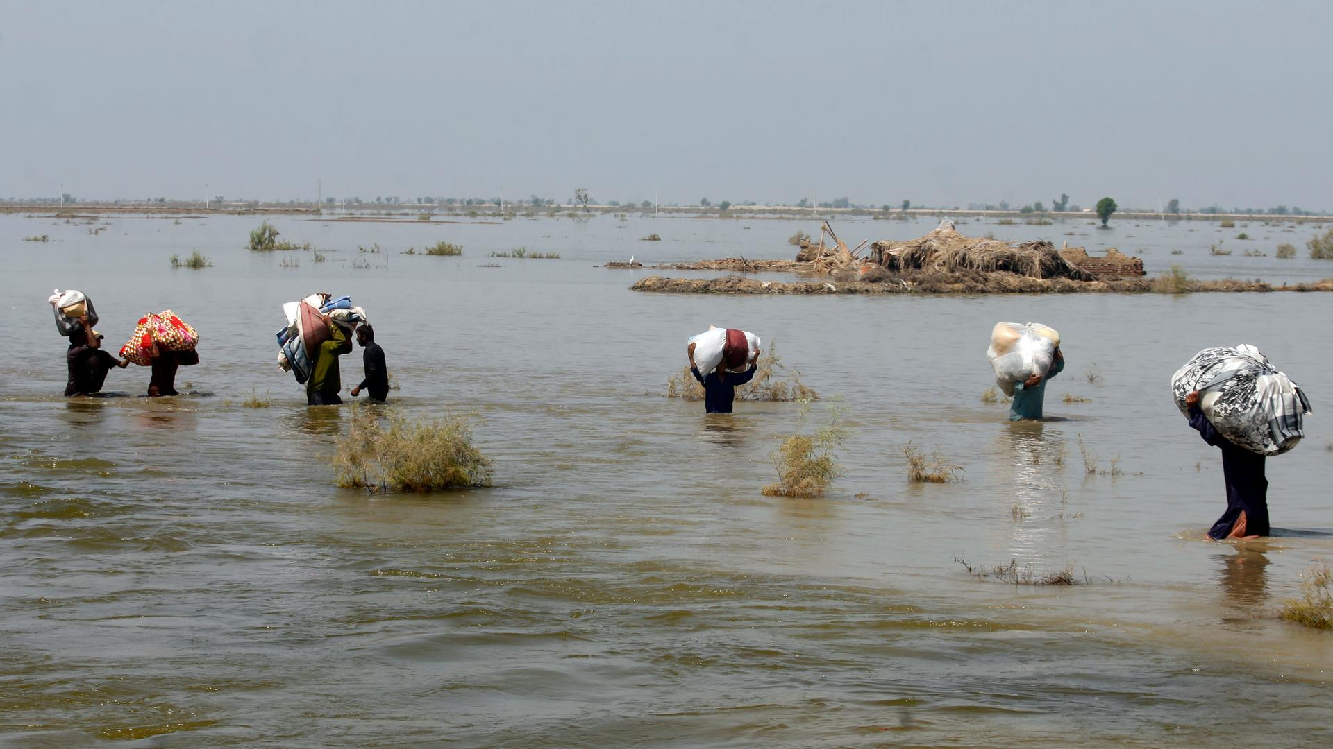 Menschen nach Überwenmmung laufen durch einen Fluss