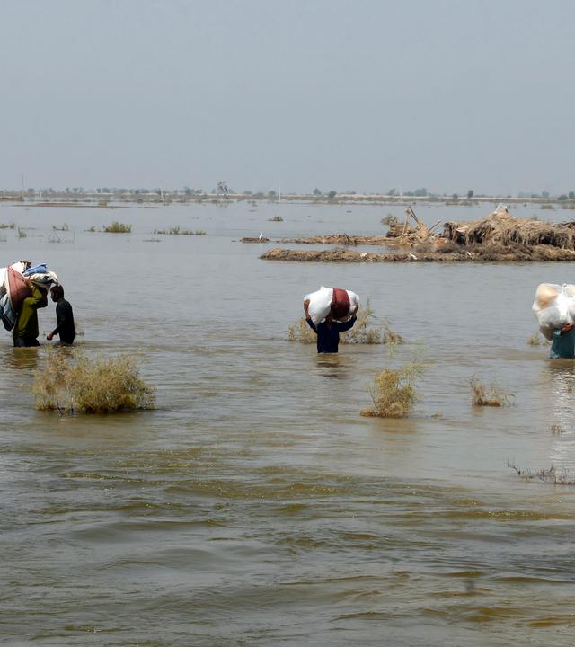 Menschen nach Überwenmmung laufen durch einen Fluss