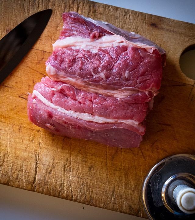 Ein Stück Fleisch auf einem Holzbrett