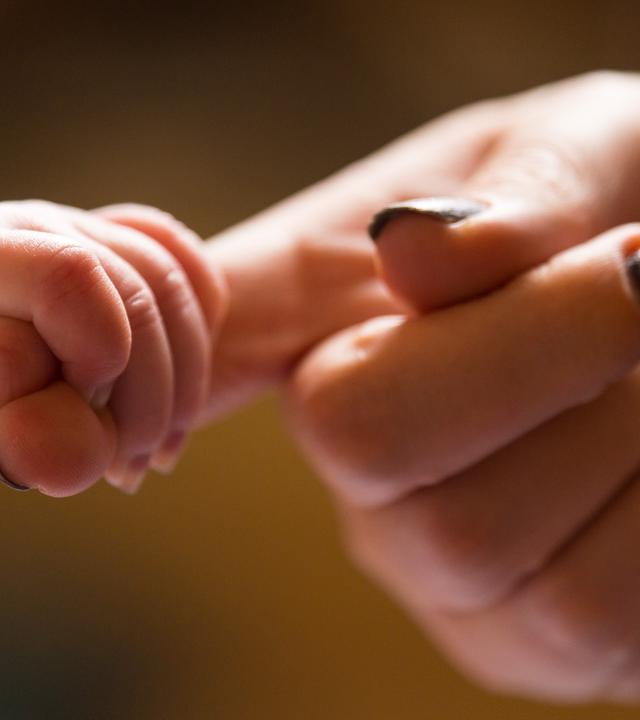 Baby hält Hand