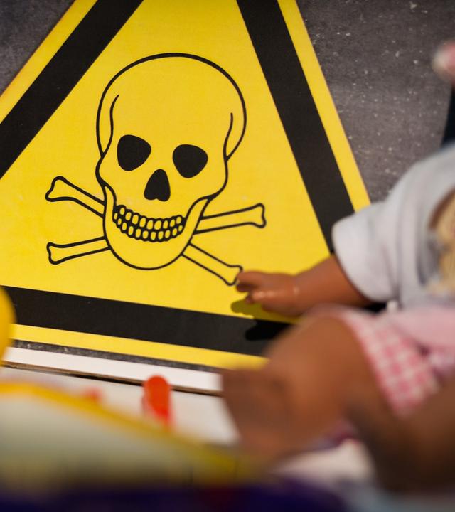 Symbol für Gift, davor Kinderspielzeug