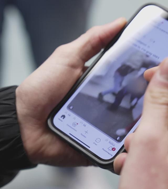 Hand hält Smartphone auf dem Gewaltvideo läuft