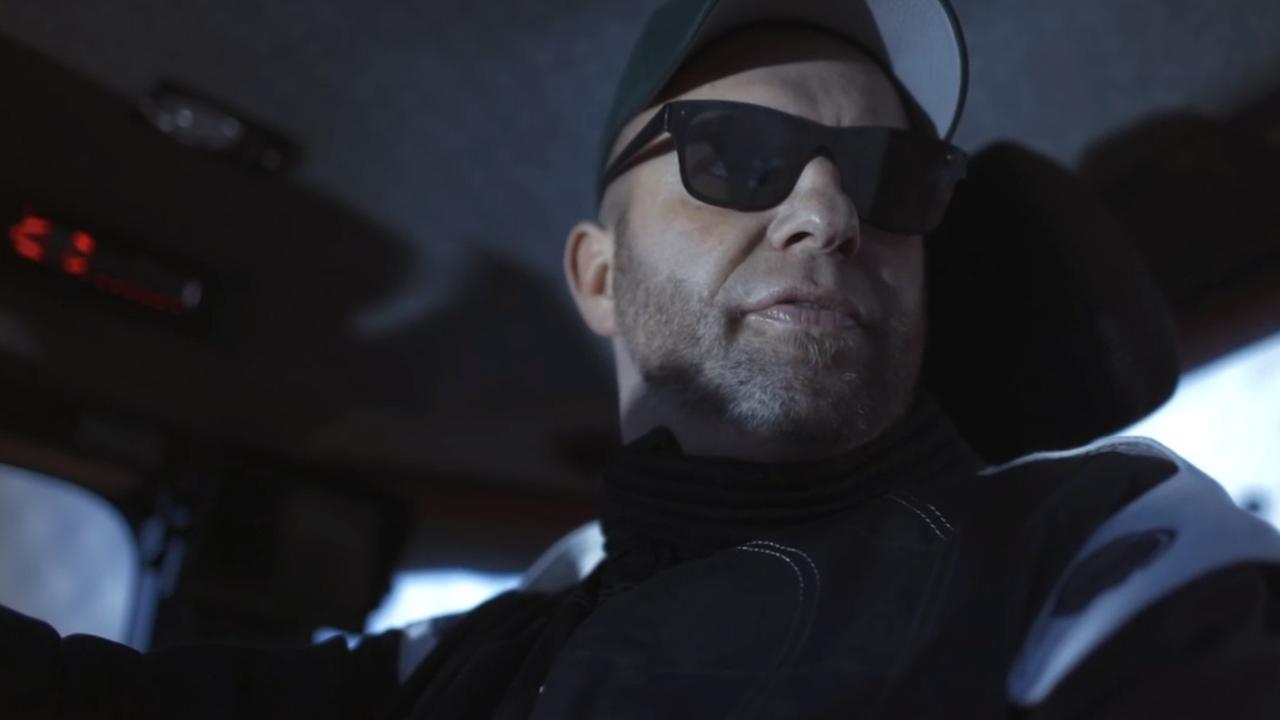 Ein Mann mit Sonnenbrille blickt zur Seite