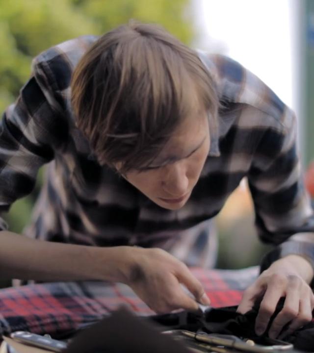 Mann beugt sich in den Motorraum