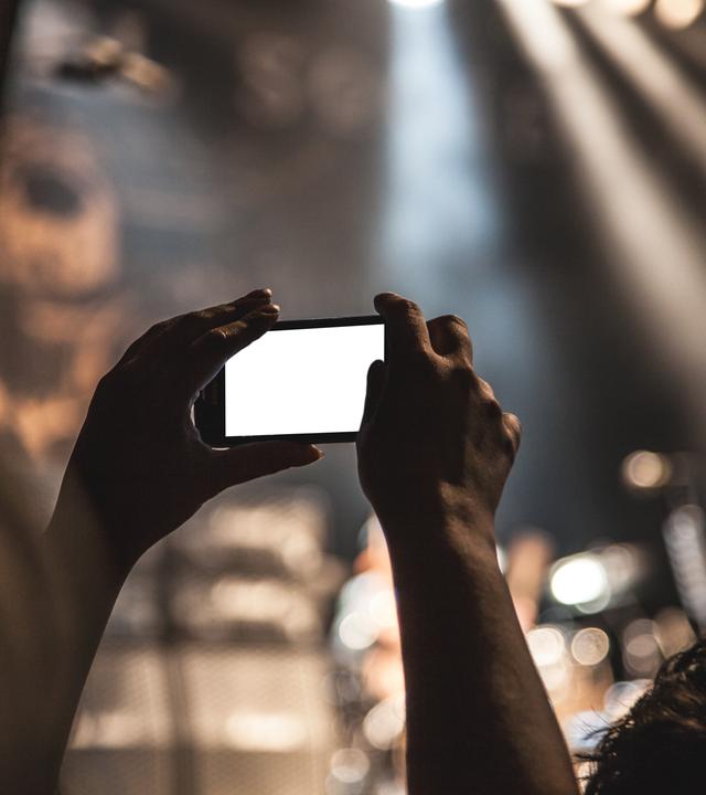 Frau hält Handy mit leerem Bildschirm in der Hand