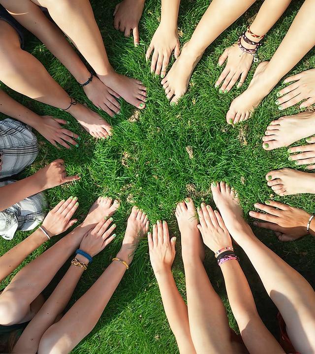 Hände und nackte Füße  in einem Kreis 