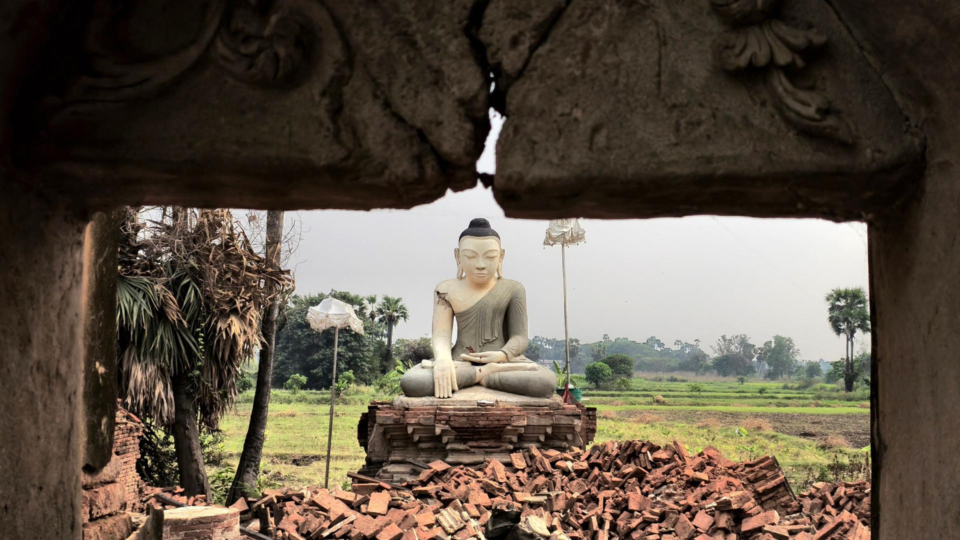 Eine Buddha-Statue ist nach dem verheerenden Erdbeben in Inn Wa am Stadtrand von Mandalay von Trümmern umgeben.