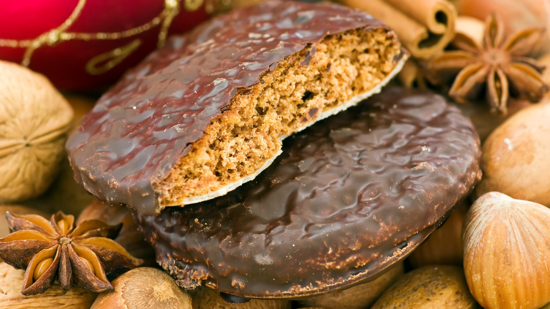 Weihnachts-Ingwerbread mit Nüssen, Zimt-Sticks und Baubles als Nahaufnahme