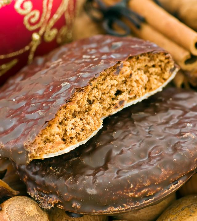 Weihnachts-Ingwerbread mit Nüssen, Zimt-Sticks und Baubles als Nahaufnahme