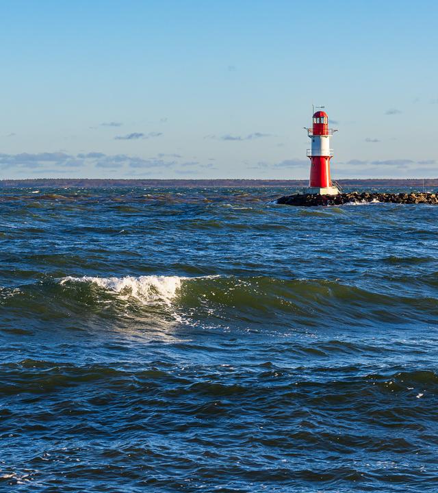 Wellen und Molenturm an der Küste der Ostsee in Warnemünde