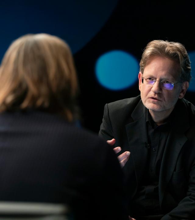 Richard David Precht diskutiert mit dem Rechtsexperten Kai Ambos. Beide sitzen sich im Studio gegenüber.