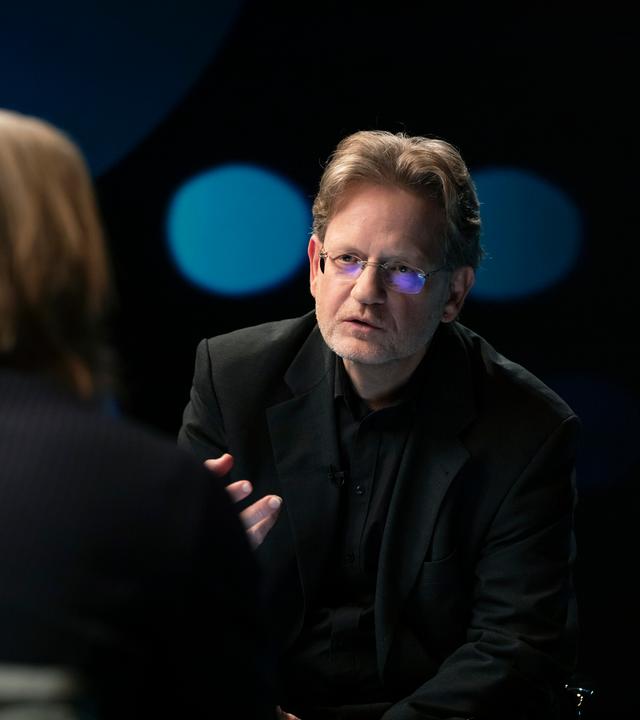 Richard David Precht diskutiert mit dem Rechtsexperten Kai Ambos. Beide sitzen sich im Studio gegenüber.