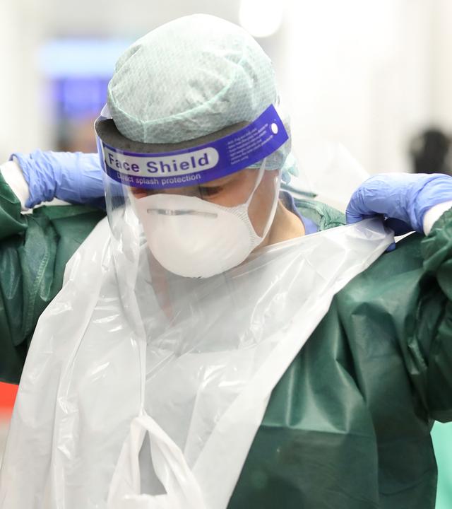 Pfleger einer Intensivsationen versucht sich die Maske abzunehmen