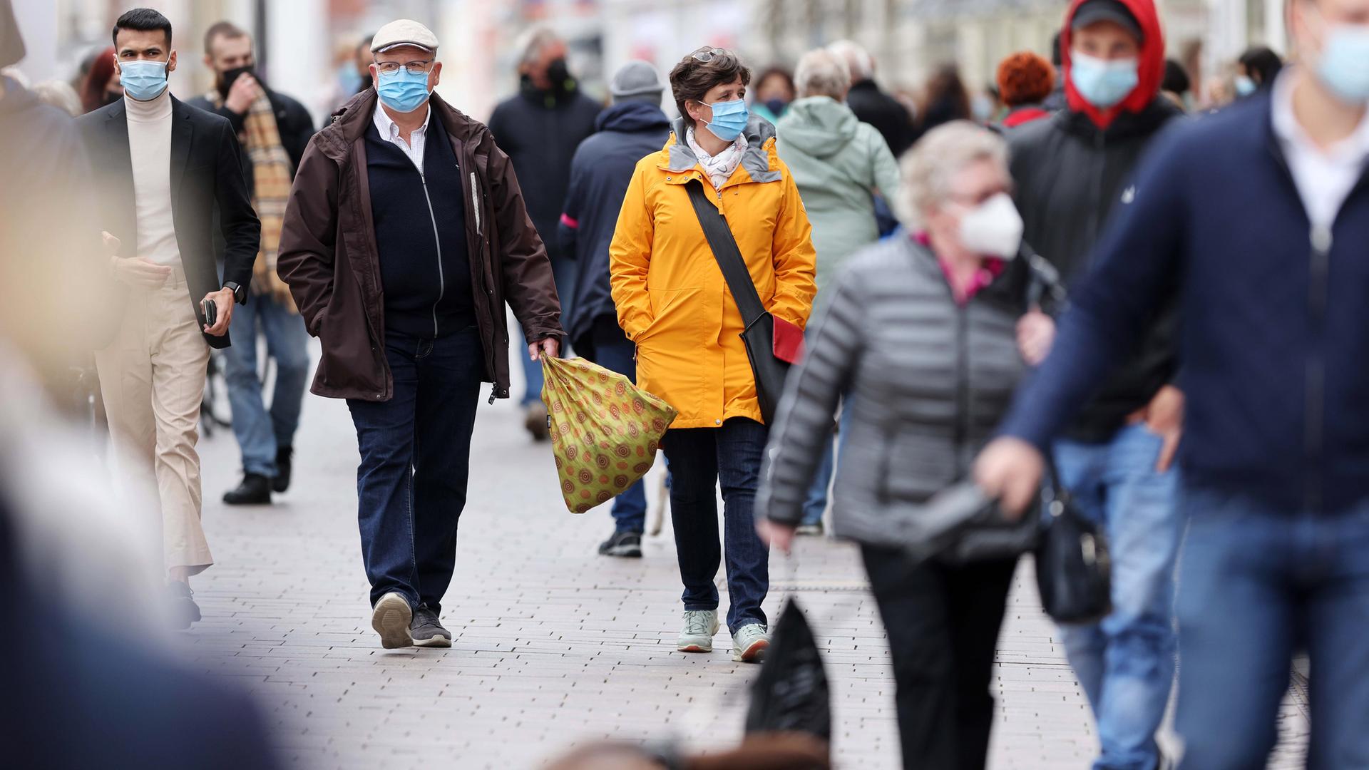 Die nächste Pandemie kommt bestimt:  Menschen mit Masken in einer Fußgängerzone