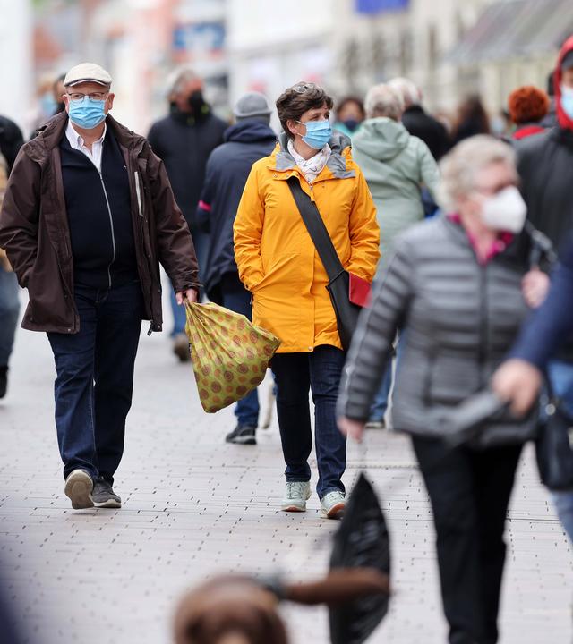 Die nächste Pandemie kommt bestimt:  Menschen mit Masken in einer Fußgängerzone