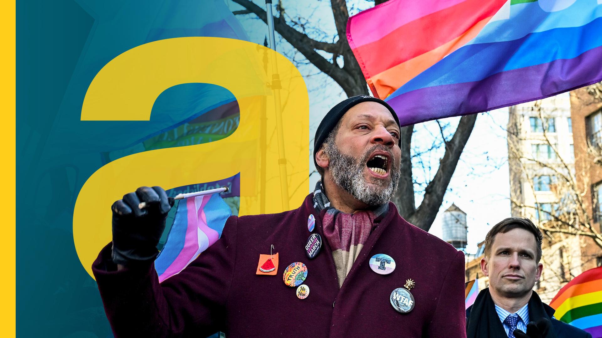 Ein Mann in der protestierenden Menge vor den LGBTQIA-Flaggen