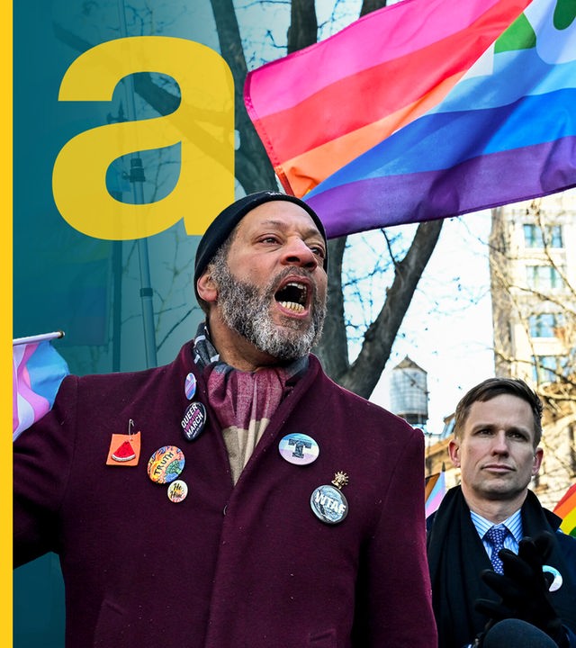 Ein Mann in der protestierenden Menge vor den LGBTQIA-Flaggen