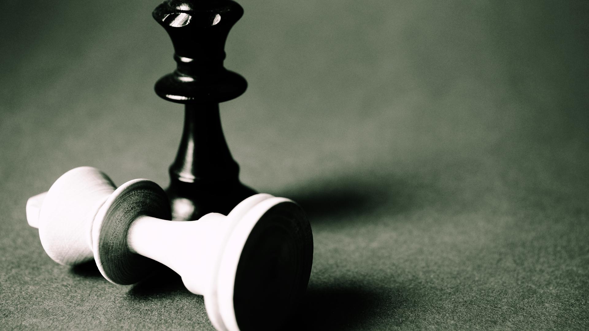 Zwei Schachfiguren auf einem Brett: Intelligenz zeigt sich im Schach durch Strategie, Planung und Lernen. 