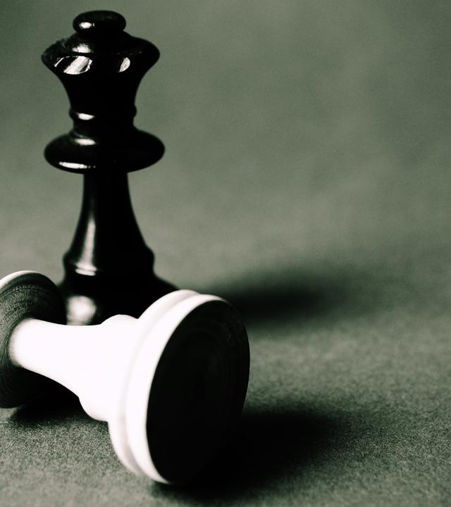 Zwei Schachfiguren auf einem Brett: Intelligenz zeigt sich im Schach durch Strategie, Planung und Lernen. 
