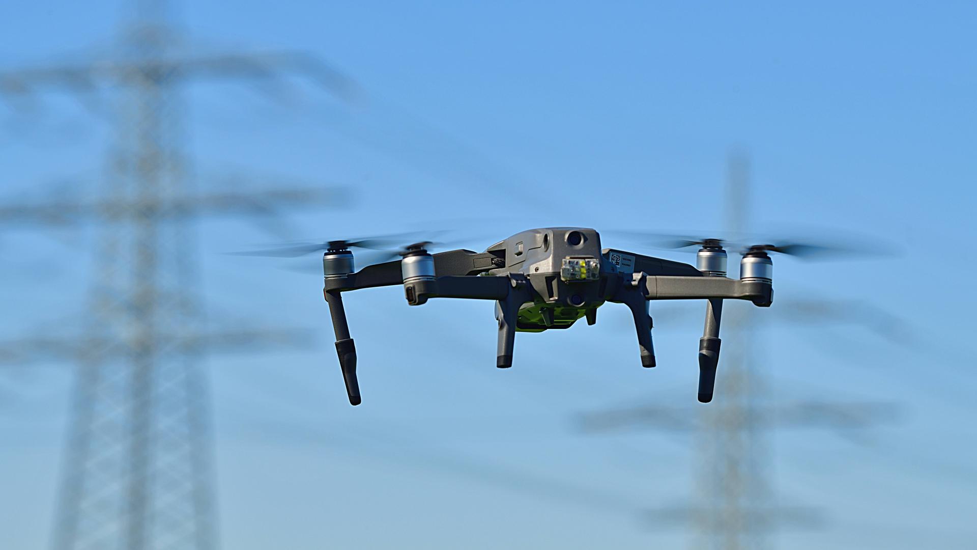 Drohne vor Strommast - Symbolbild