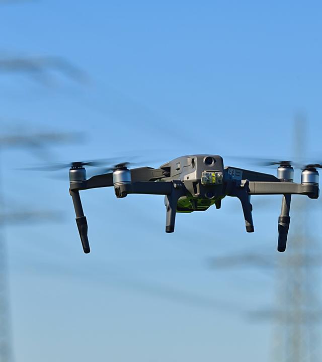 Drohne vor Strommast - Symbolbild