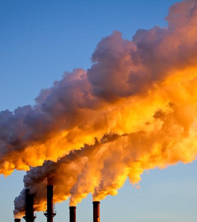 Sie sollen bald der Vergangenheit angehören - rauchende Schornsteine einer Industrieanlage. Doch noch symbolisieren sie CO₂-Emissionen und die Herausforderungen der Klimapolitik beim EU-Gipfel in Brüssel zum Ziel 2040.