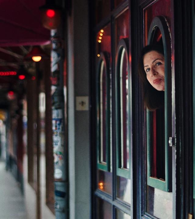 Zu sehen ist die leere Herbertstraße. Auf der rechten Seite des Bildes kann man die Separees der Prostituierten erkennen. Aus einem der Fenster streckt Manuela Freitag ihren Kopf und blickt auf die Straße.