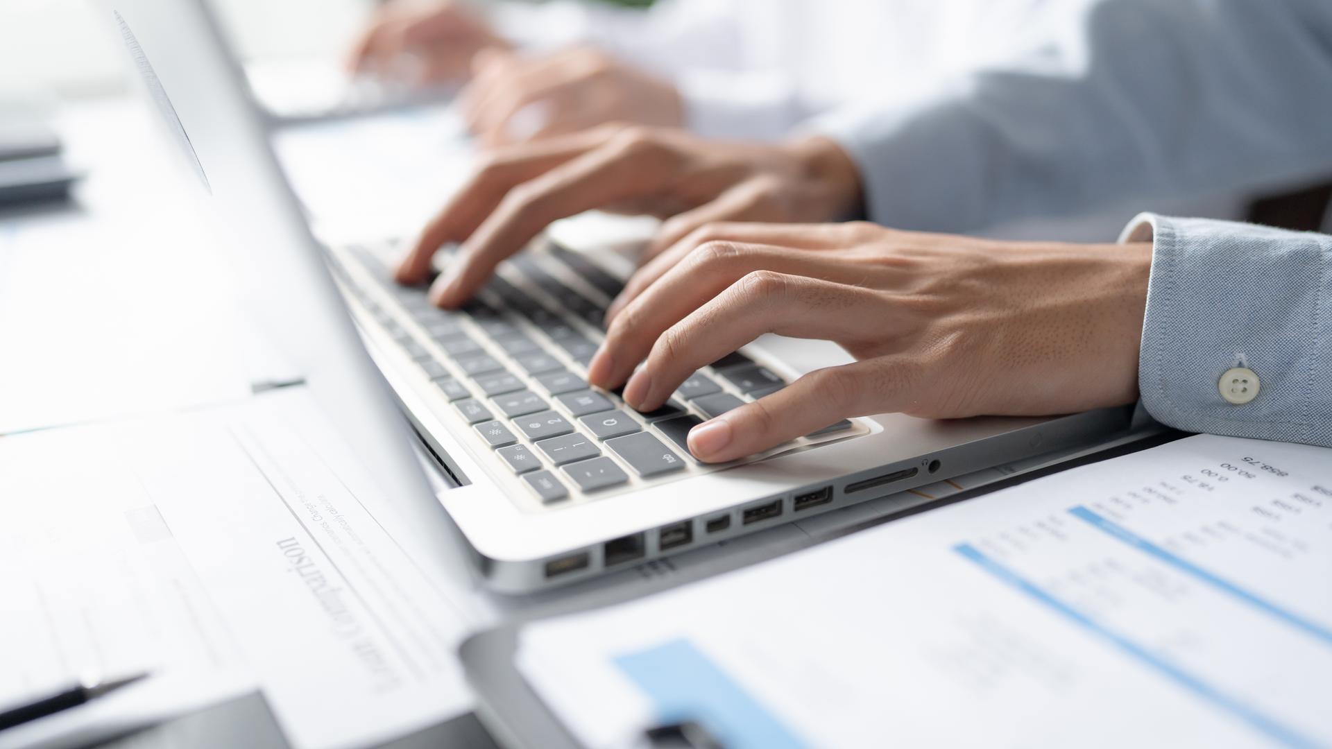 Hände schreiben an PC