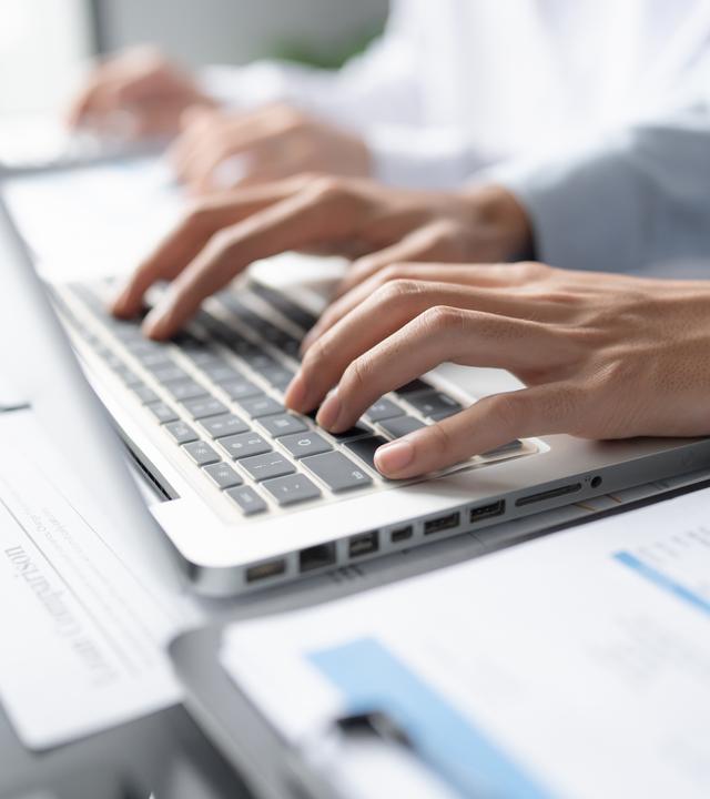 Hände schreiben an PC