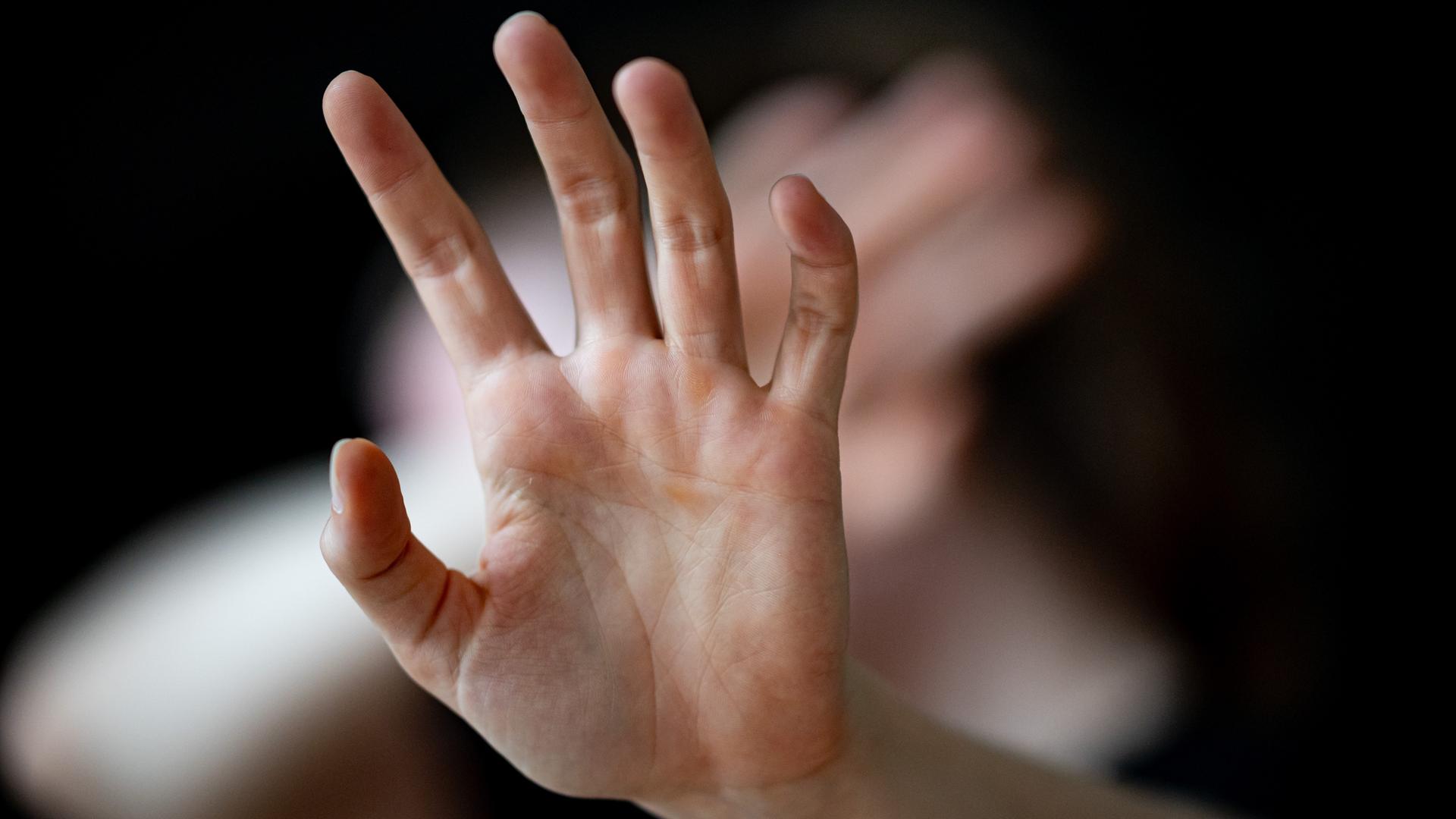 in Abwehr erhobene Hände einer Frau