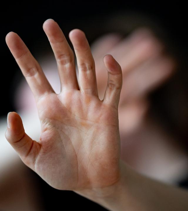 in Abwehr erhobene Hände einer Frau