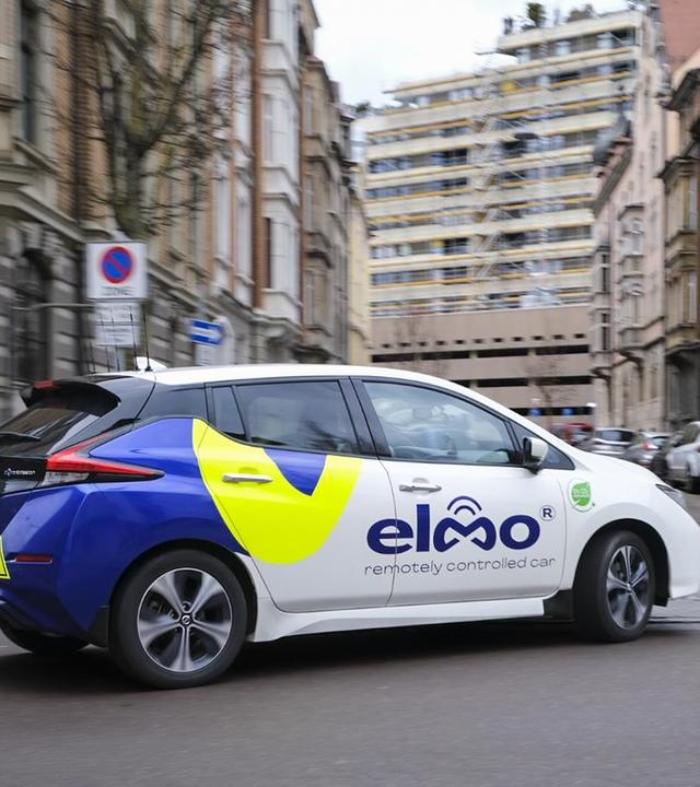 Das Auto von Elmo fährt ohne Fahrer, gesteuert aus der Ferne. Mit mehreren Kameras und schnellen Netzwerken wird es sicher durch den Stadtverkehr manövriert.