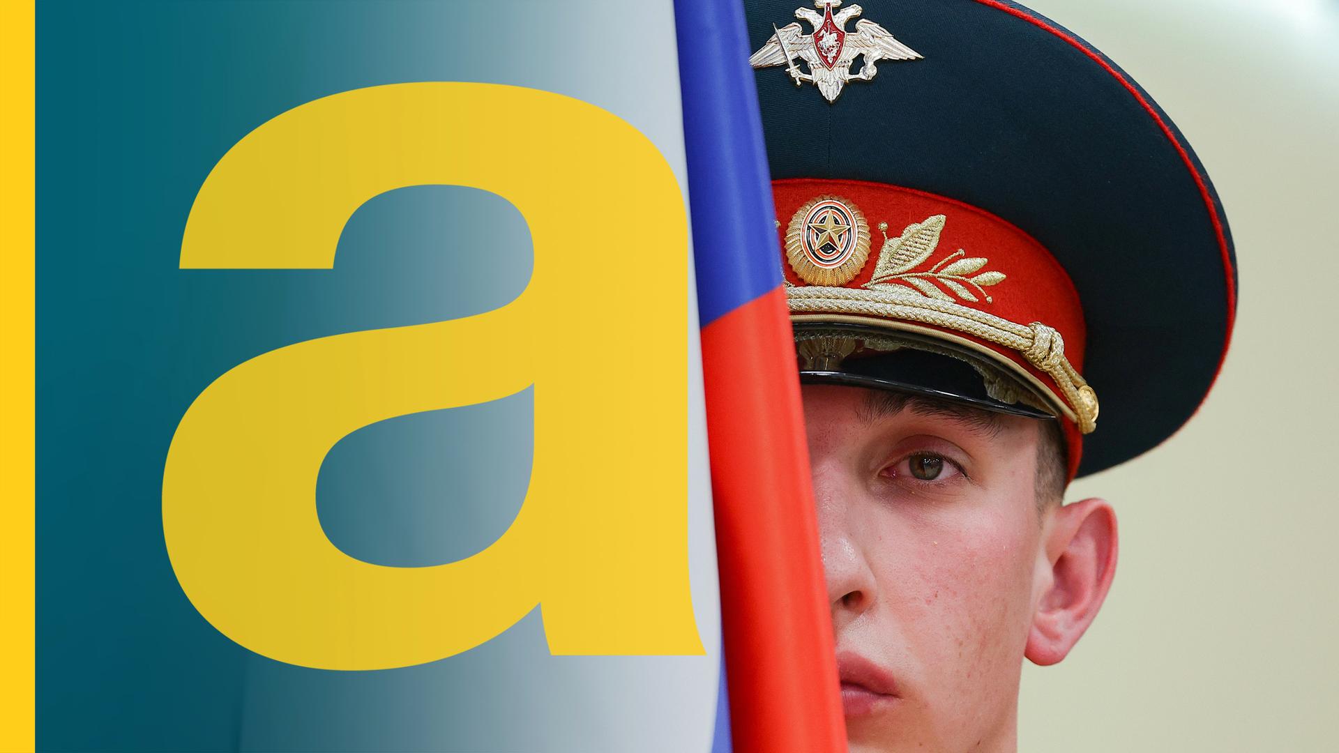 Ein russischer Soldat mit Soldatenhut. Sein Gesicht wird zur Hälfte von einer russischen Flagge verdeckt.