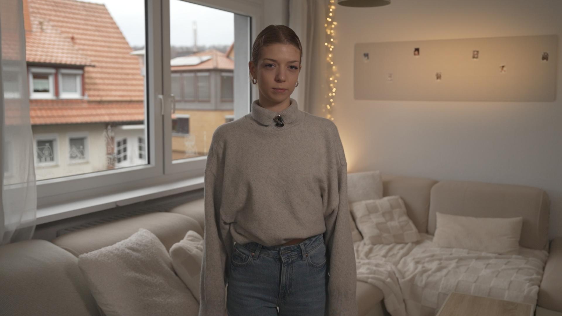 "37°Leben: Gefangen im Kopf: Leben mit Zwangsstörung": Phoebe steht in ihrem Wohnzimmer und blickt in die Kamera.