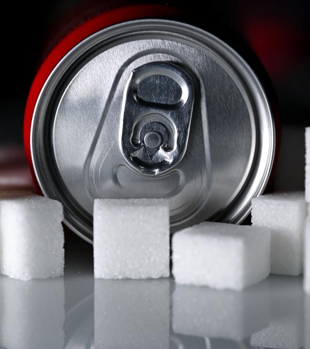 Zuckersteuer beschlosse: Dose Softdrink liegt neben Zuckerwürfeln – Symbol für Zuckergehalt und Debatte über Zuckersteuer und Ersatzstoffe.