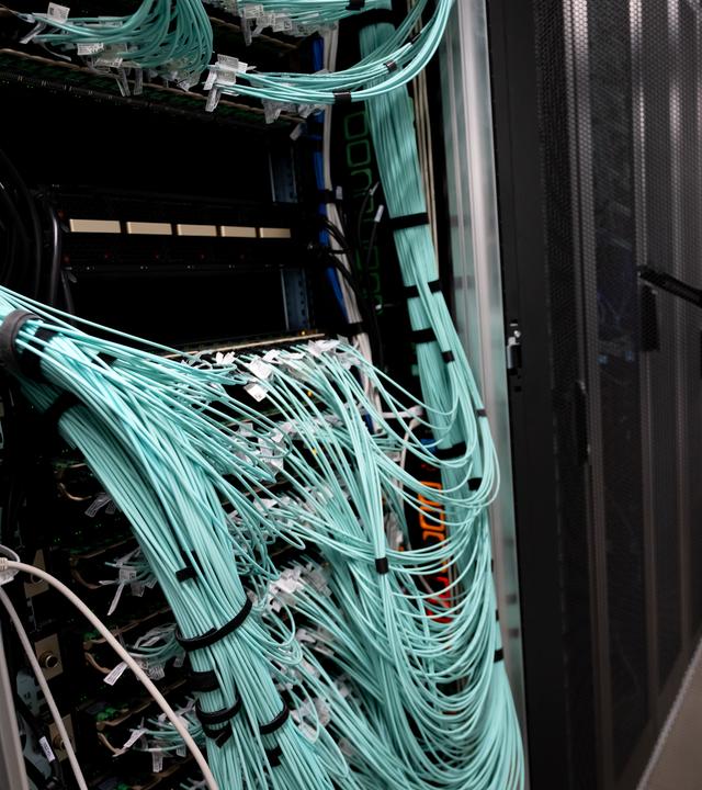 Ressourcen-Krise durch Big Tech: Jede KI-Anfrage fordert die globale Strom- und Wasserinfrastruktur in den Server-Farmen (Serverschränke mit Netzwerkkabeln sind in einem Rechenzentrum)