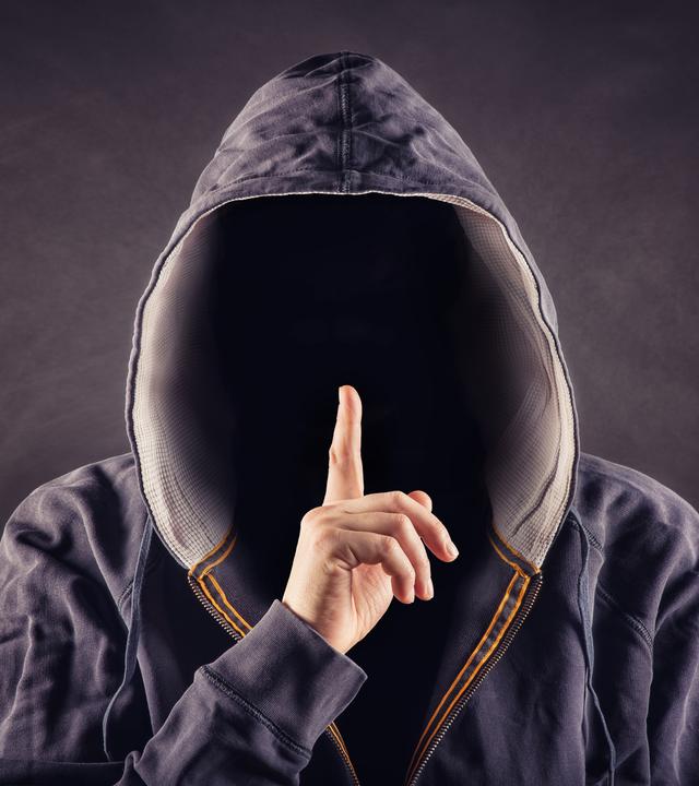 Ausländischen Geheimdiensten rekrutieren über Chats Laien-Spione als Wegwerf-Agenten. Wer scheinbar banale Aufträge annimmt, riskiert Jahre im Knast. (Bild: Mann mit Kaputze, im Dunkeln)