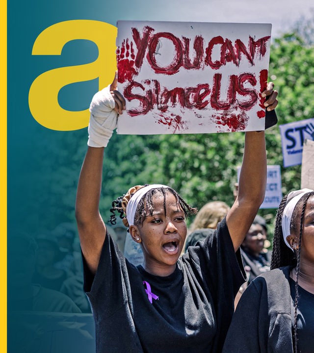 Frauen halten Plakate hoch, während sie an einer Demonstration in Südafrika teilnehmen.