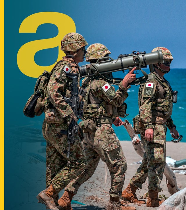 Drei japanische Soldaten bei einer Übung auf den Philippinen vor dem blauen Meer.