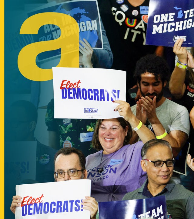 Anhänger der Demokratischen Partei auf einer Tribüne mit "Elect Democrats"-Plakaten.