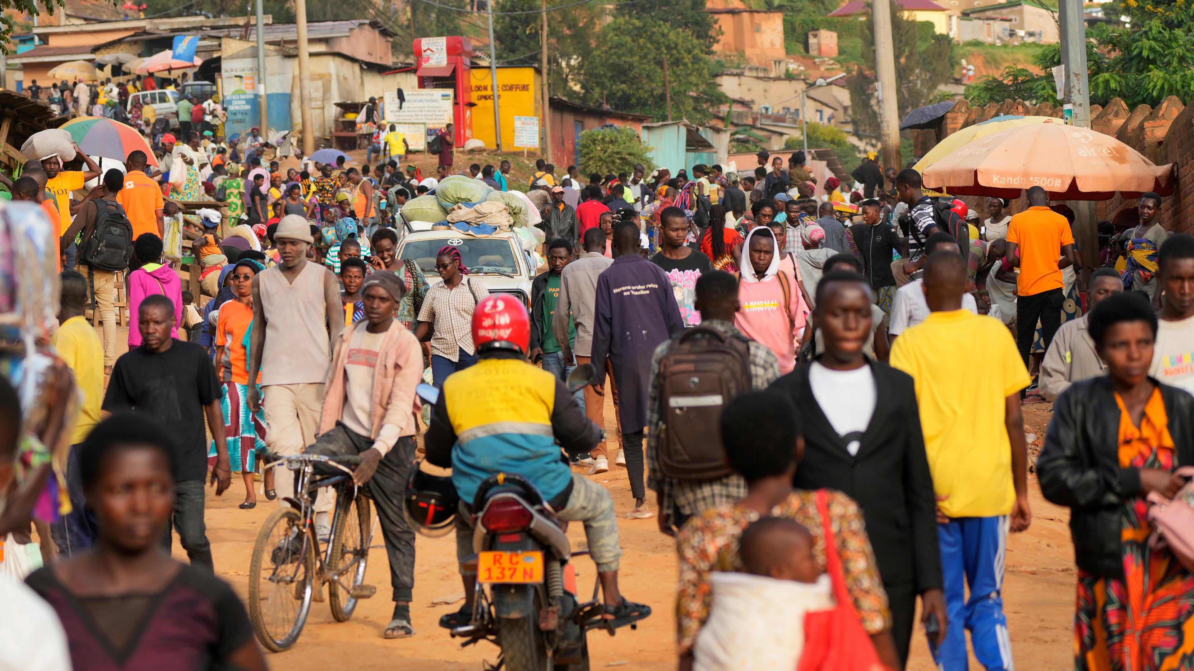 Eine große Menschenmenge in einer Siedlung in Ruanda.