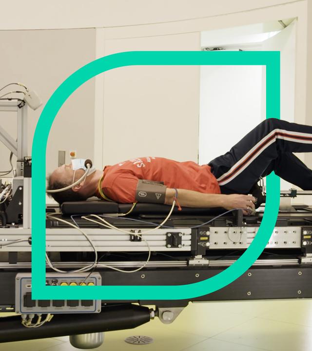 Ein Mann liegt auf einer Trage und tritt in Pedale