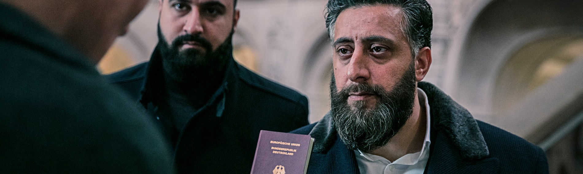 Toni Hamady (Kida Khodr Ramadan) zeigt dem Polizeibeamten Hagen Kutscha (Oliver Masucci) seinen deutschen Pass.