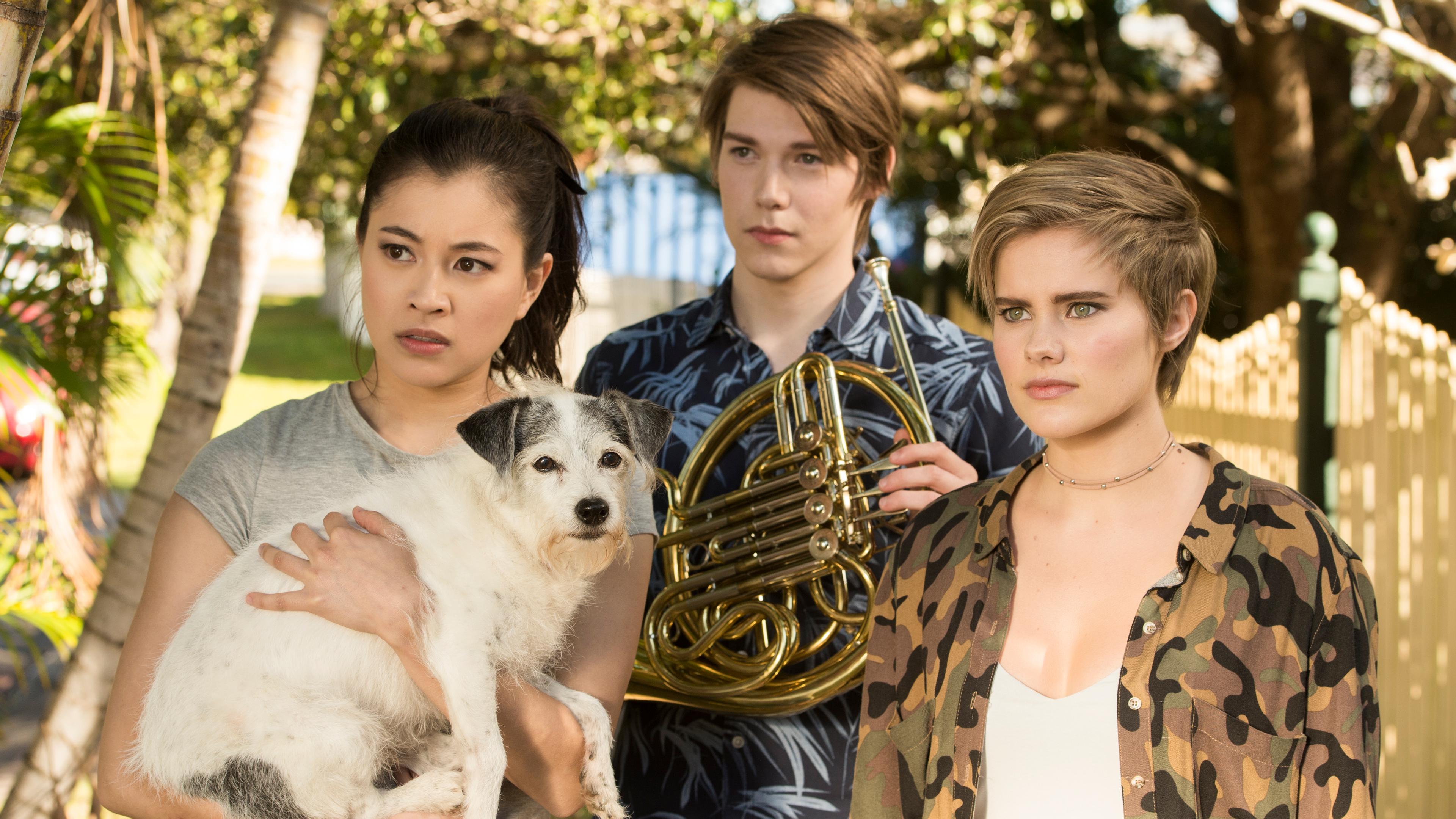 Kyra (links), Darra (Mitte) und Imogen (rechts) schauen verwirrt. Kyra hat einen Hund auf dem Arm.