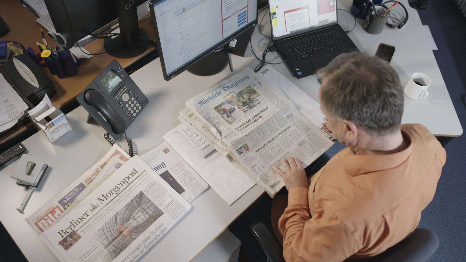 Ein ZDF-Mitarbeiter liest Zeitung