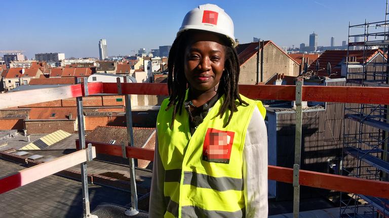 "plan b: Bezahlbares Zuhause - Rezepte gegen Wohnungsnot": Massandjé Bamba steht im Rohbau ihrer eigenen Wohnung. Sie trägt Schutzkleidung und einen Schutzhelm.