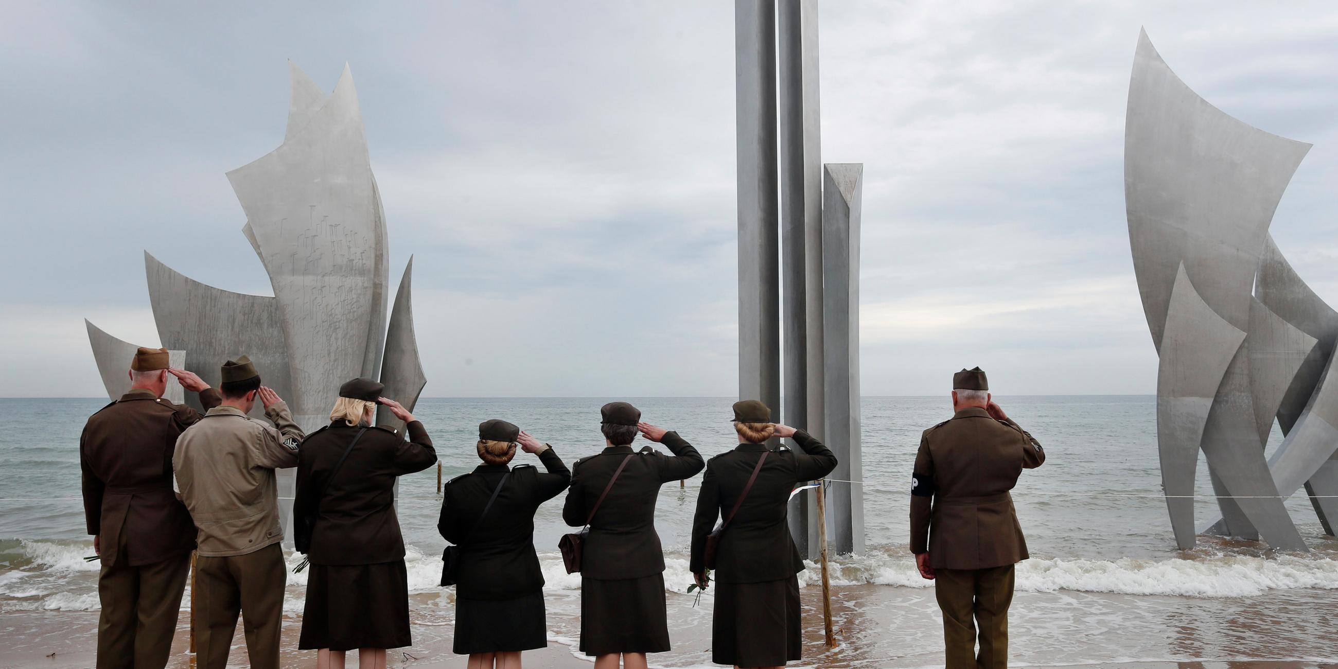 Zweite-Weltkrieg Liebhaber stehen vor ein Denkmal für die amerikanischen Soldaten, die am Tag des Tages am Omaha-Strand landeten am 04.06.2019 in Saint-Laurent-Sur-Mer (Frankreich) 