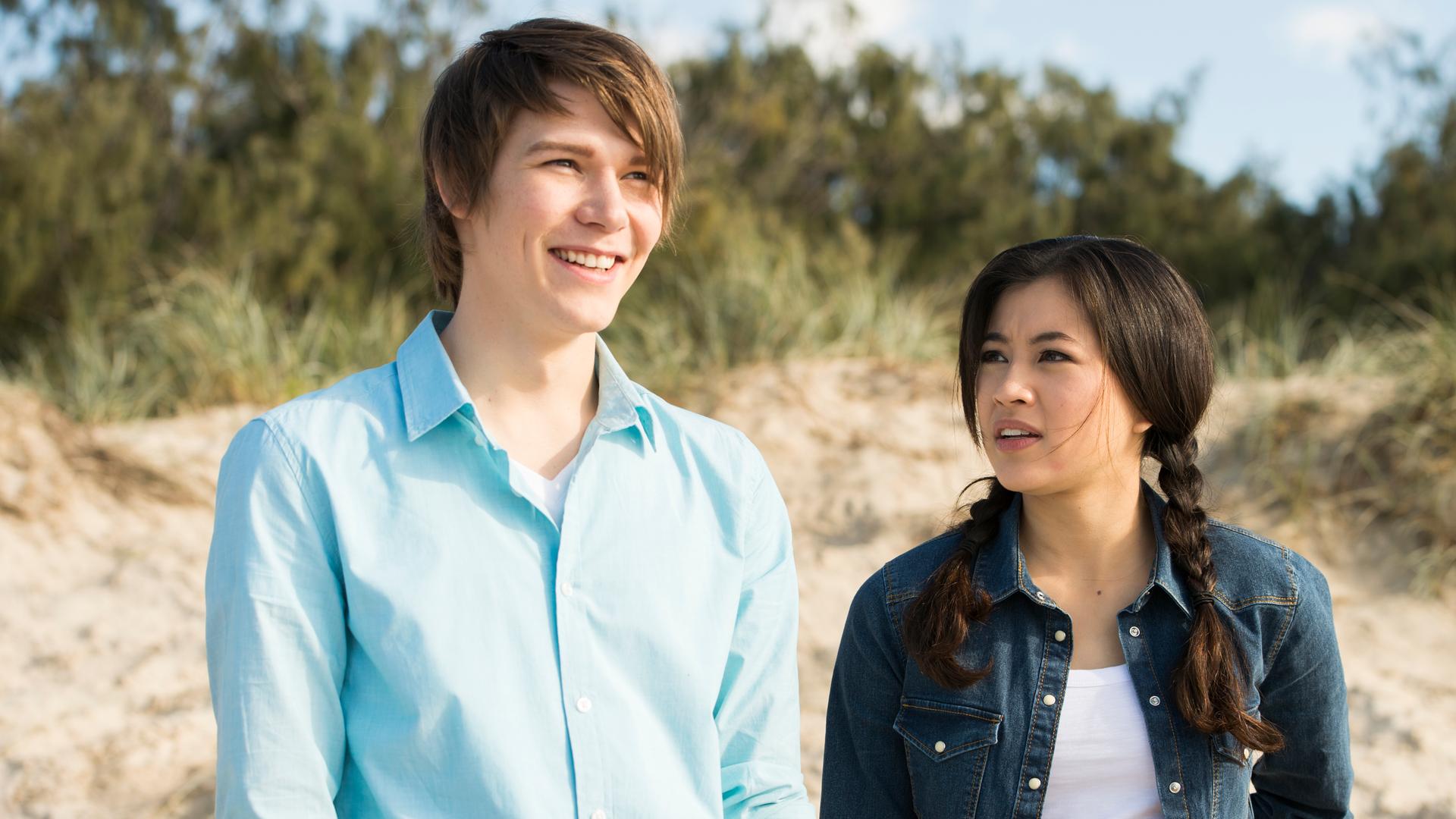 Darra und Kyra stehen am Strand. Darra lächelt.