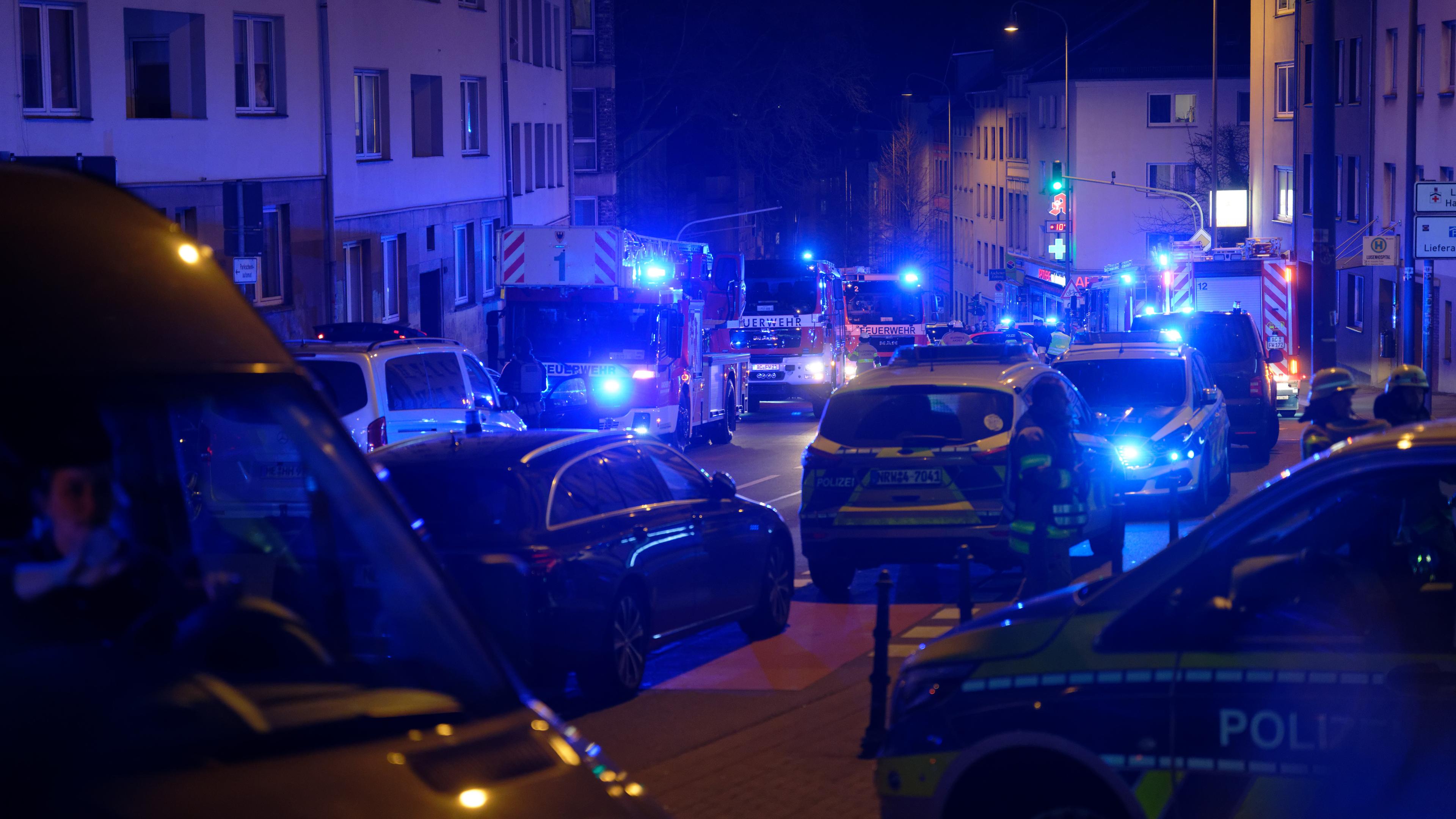 Einsatzfahrzeuge von Polizei und Feuerwehr stehen vor einem Aachener Krankenhaus. 